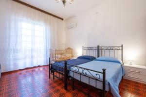 a bedroom with a bed and a large window at Il Faro in Sarroch