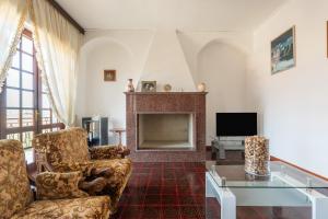 a living room with a fireplace and a tv at Il Faro in Sarroch
