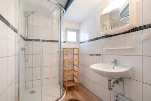a bathroom with a shower and a sink at Bungalow Netzboden, Bgl 28 in Dranske +16 photos