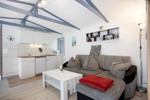 a living room with a couch and a table at Bungalow Netzboden, Bgl 28 in Dranske