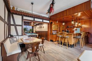 a kitchen with wood paneling and a bar with stools at Gruppenhaus Osterhagen in Bad Lauterberg