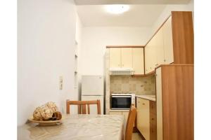 a small kitchen with a table and a refrigerator at Manolika Studio 1 in Kithnos