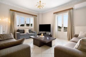 a living room with two couches and a tv at Christine's House in Zakynthos