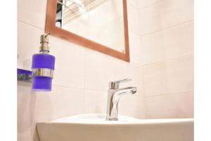 a bathroom sink with a blue soap bottle on it at Manolika Studio 1 in Kithnos