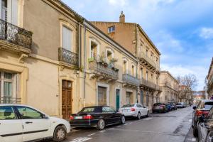 a group of cars parked on a street with buildings at Le Voltaire pour 4 in Sète
