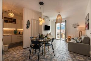 a kitchen and a living room with a table and chairs at Casa Royale Appartamento Acqua in Lierna