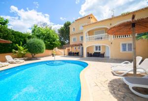 a villa with a swimming pool in front of a house at Verano in Calpe