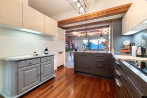 a kitchen with gray cabinets and a large window at Lake Como - Incanto in Valvarrone