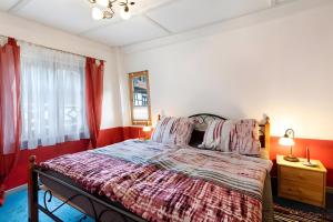 a bedroom with a bed with red walls and a window at Ferienwohnung im Strumpfweberhaus in Schiltach