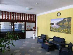 a waiting room with chairs and a clock on the wall at Schloss Grubhof Appartement in Sankt Martin bei Lofer