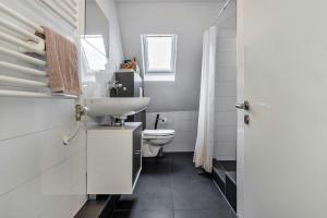 a white bathroom with a sink and a toilet at Ferienwohnung zur Grenze in Gronau