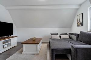 a living room with a couch and a tv at Ferienwohnung zur Grenze in Gronau