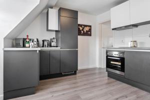 a kitchen with gray cabinets and a stove at Ferienwohnung zur Grenze in Gronau +11 photos