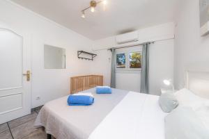 a white bedroom with a large white bed with blue pillows at Costa den Blau in Porto Cristo