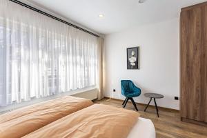 a bedroom with a bed and a chair and a window at Ferienwohnung Sophie Stecker in Schmallenberg
