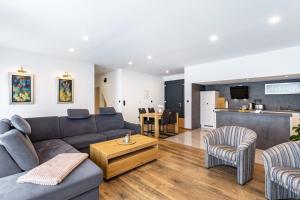 a living room with a couch and chairs and a kitchen at Ferienwohnung Sophie Stecker in Schmallenberg