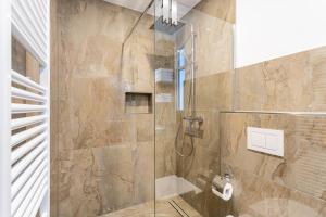 a bathroom with a shower with a glass door at Ferienwohnung Sophie Stecker in Schmallenberg +23 photos
