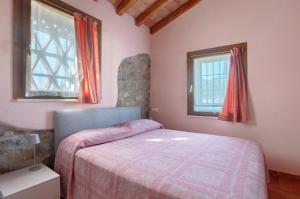 a bedroom with a bed and two windows at Villa Gardenia - Private Garden in Sarzana
