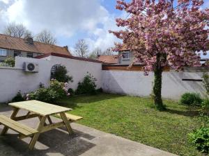 a picnic table in a yard with a flowering tree at l'auberge des trois lieux in Calais