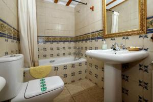 a bathroom with a toilet and a sink and a tub at El Molino del pepe in Almajano
