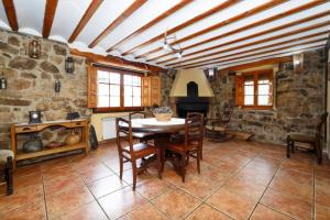 a dining room with a table and a stone wall at El Molino del pepe in Almajano
