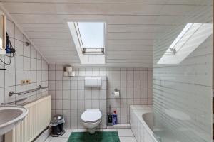 a bathroom with a toilet and a sink and a tub at App und Fewos Wolf in Usingen +60 photos