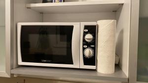 a microwave on a shelf with a roll of paper towels at Appartment nahe Galopprennbahn in Iffezheim
