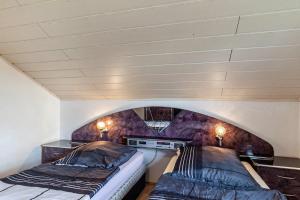two beds in a room with an arched ceiling at App und Fewos Wolf in Usingen