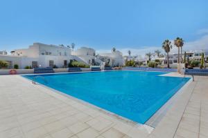 a large swimming pool in a villa with white buildings at Casa Lotti With Ocean View in Santa Cruz de Tenerife