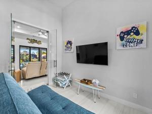 a living room with a blue couch and a tv at Waterfront Haven with Pool Spa Game Room in Port Charlotte