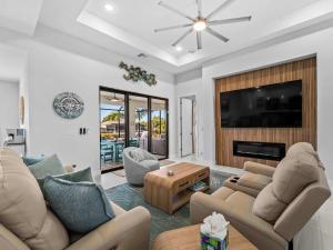 a living room with couches and a flat screen tv at Waterfront Haven with Pool Spa Game Room in Port Charlotte