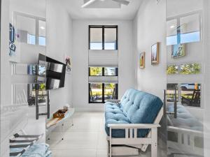 a living room with a blue chair and a tv at Waterfront Haven with Pool Spa Game Room in Port Charlotte