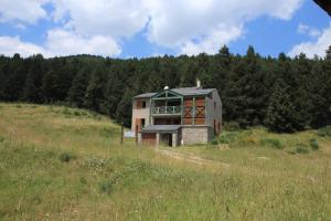 a house on top of a hill in a field at Chalet Pla Del Mir in Les Angles