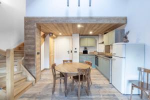 a kitchen with a wooden table and a refrigerator at Les Petits Loups in Morillon +12 photos