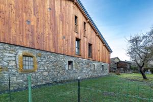 a large stone building with a fence in front of it at Les Petits Loups in Morillon