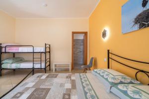 a bedroom with two bunk beds and a chair at Il cappello sulle 23 in Avola