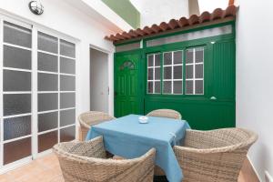 a table and chairs in a room with a green door at Arenas de Sal in La Mareta