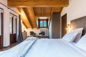 a bedroom with a large white bed with wooden ceilings at Casa Facco in Bocenago
