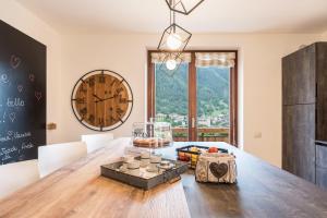a dining room with a table and a large clock at Casa Facco in Bocenago