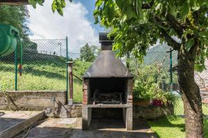 a brick oven in a yard next to a fence at Casa Facco in Bocenago
