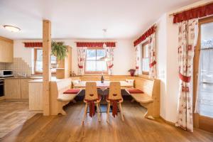 a kitchen and dining room with a table and chairs at Ciasa Tlara App Alma in San Vigilio Di Marebbe +13 photos