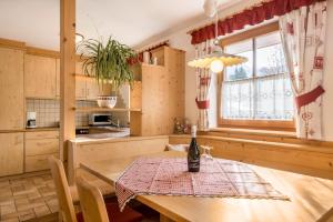a kitchen with a table with a bottle of wine on it at Ciasa Tlara App Alma in San Vigilio Di Marebbe