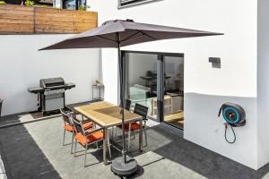 a table and chairs with an umbrella on a patio at Stegmann Horn in Gaienhofen