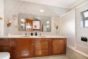 a bathroom with two sinks and a mirror at Casa Judite in Lagoa +24 photos