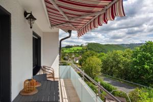 a balcony with an umbrella and a view at Ferienwohnung Lux in Plettenberg