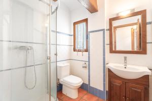 a bathroom with a toilet and a sink and a shower at Cueva De La Portería in Chulilla