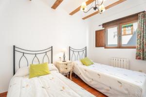 a bedroom with two beds and a window at Cueva De La Portería in Chulilla
