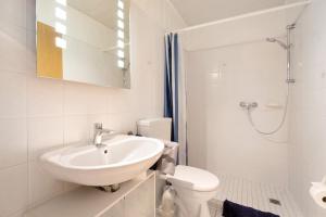 a white bathroom with a sink and a toilet at Bi Tiessens to Hus in Arkebek +14 photos
