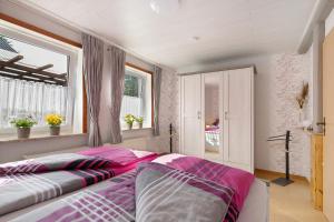 a bedroom with two beds and a window at Bi Tiessens to Hus in Arkebek