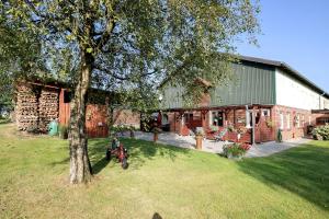 a house with a motorcycle parked next to a tree at Bi Tiessens to Hus in Arkebek